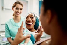 Patient smiling at reflection in treatment chair