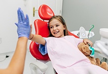 Little girl giving high-five to dental team member