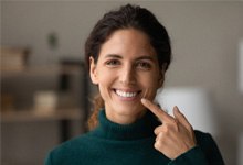 Smiling woman pointing to her teeth