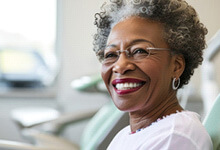 Older woman in Crookston smiling with implant dentures