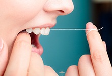 Woman flossing her teeth