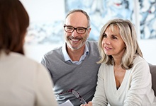 Couple at a dental implant consultation discussing who dental implants can help