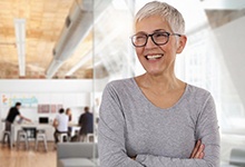 Happy woman standing with her arms crossed and dental implant tooth replacement