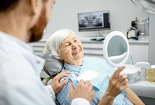 Woman admiring her new smile after getting dental implants