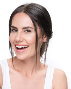 a patient smiling and holding her Spark clear aligner