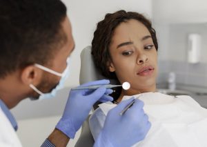 person with dental anxiety staring at dental tools being held by a dentist