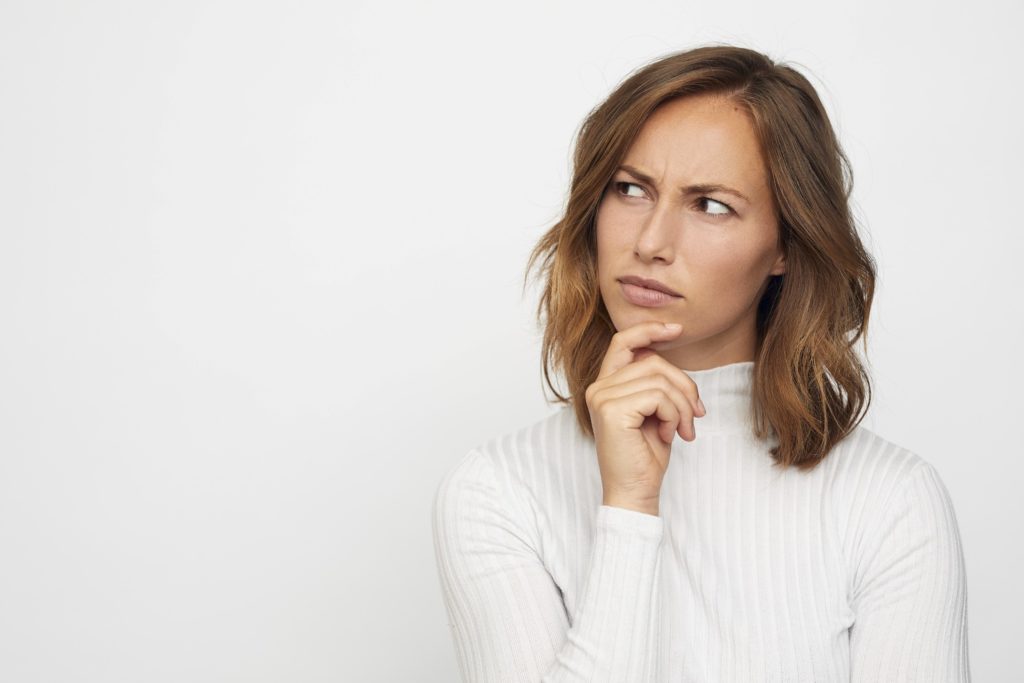 Closeup of woman in white shirt contemplating