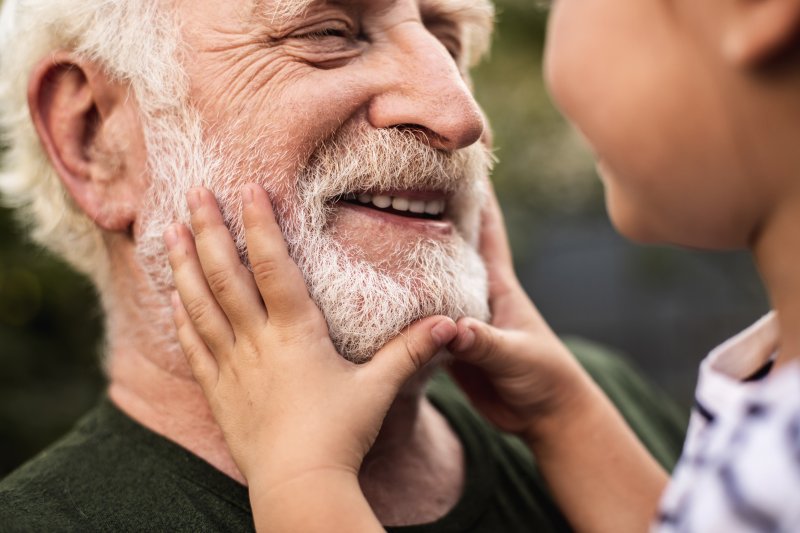 An older man smiling at his grandson
